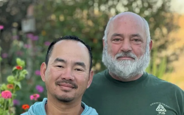 Rich and Nghi smiling together in the garden